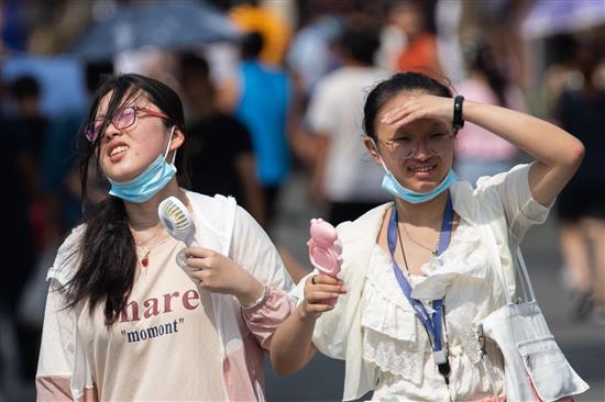 8月2日，两个女孩经过热浪滚滚的南京街头。当日，南京市气象台继续发布高温黄色预警信号，最高气温达35℃以上。泱波/中新社 图